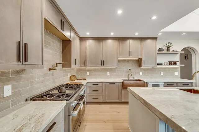 a kitchen with stainless steel appliances granite countertop a sink stove and cabinets