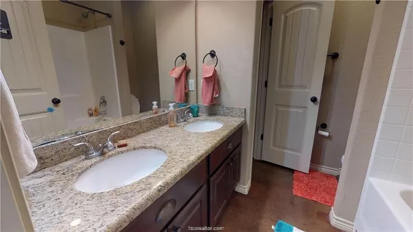 a bathroom with a granite countertop sink and a mirror