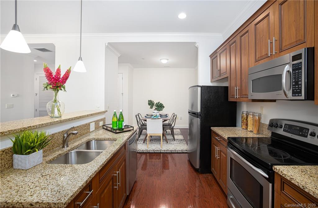 230 South Tryon Street, Unit 305 Charlotte, NC 28202 - Photo 12 of 32 a kitchen with granite countertop a sink stove and refrigerator
