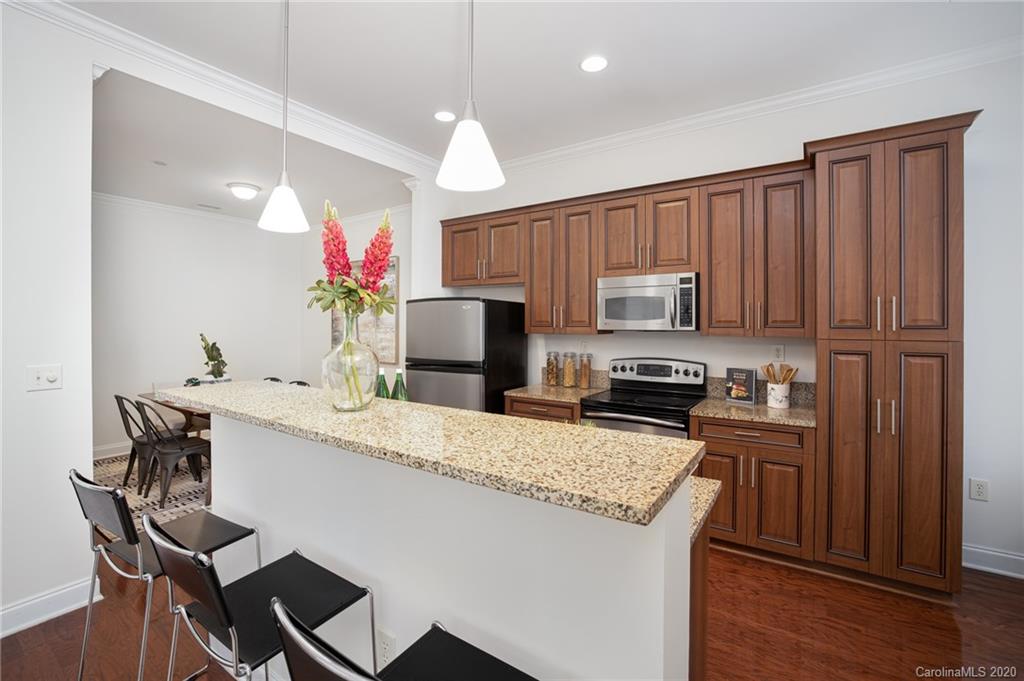 230 South Tryon Street, Unit 305 Charlotte, NC 28202 - Photo 15 of 32 a kitchen with kitchen island a sink stove and microwave
