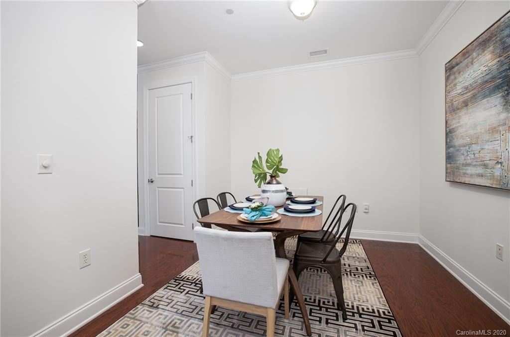 230 South Tryon Street, Unit 305 Charlotte, NC 28202 - Photo 19 of 32 a view of a dining room with furniture and wooden floor