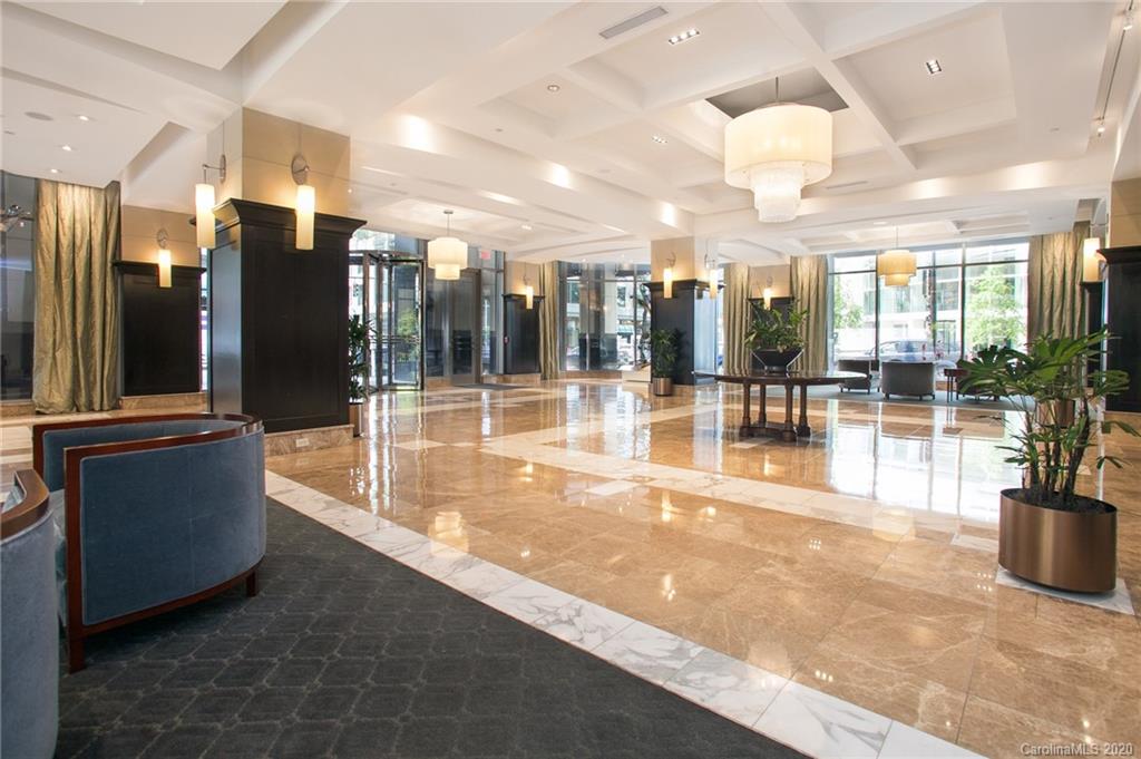 230 South Tryon Street, Unit 305 Charlotte, NC 28202 - Photo 3 of 32 a lobby with furniture and floor to ceiling window