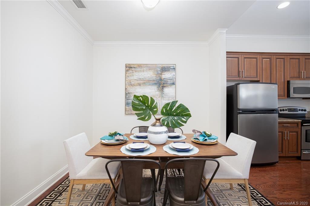 230 South Tryon Street, Unit 305 Charlotte, NC 28202 - Photo 8 of 32 a dining room with furniture and wooden floor