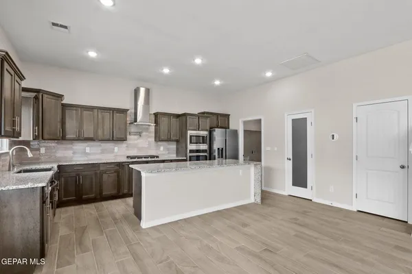 an empty room with wooden floor and entryway
