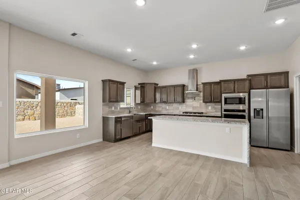 a kitchen with stainless steel appliances granite countertop a sink stove and refrigerator