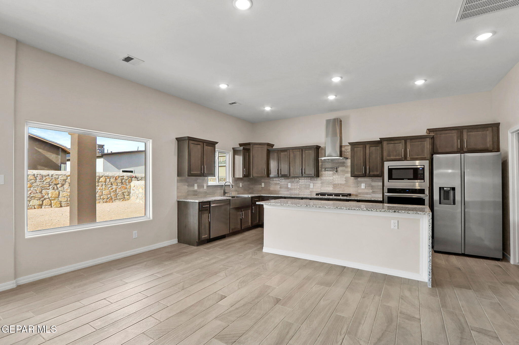 15313 Resolve Drive El Paso, TX 79938 - Photo 18 of 45 a kitchen with stainless steel appliances granite countertop a refrigerator a sink dishwasher a oven with white cabinets and wooden floor