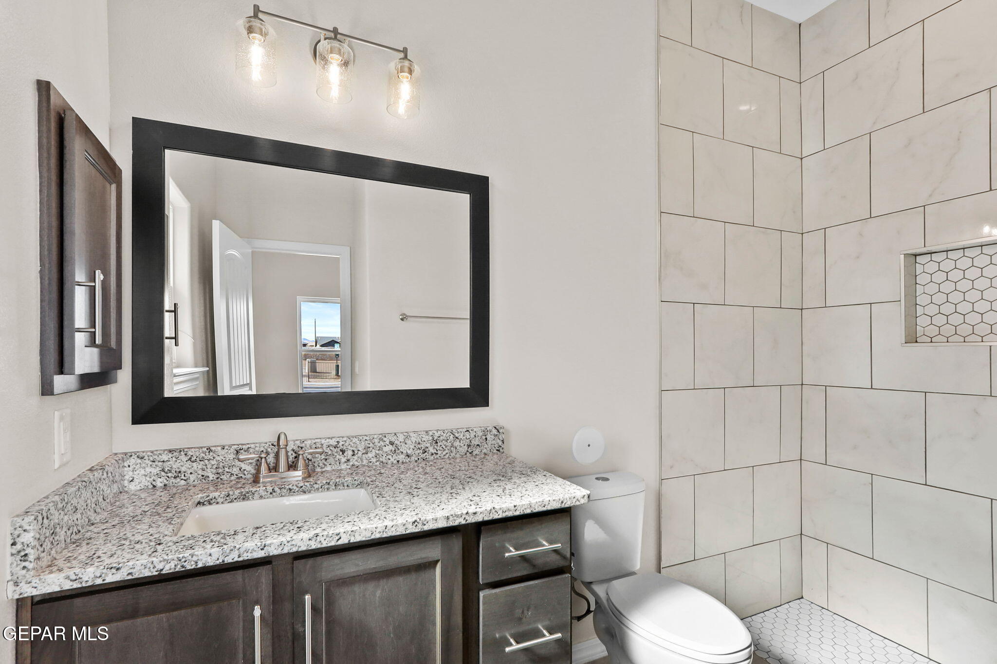 15313 Resolve Drive El Paso, TX 79938 - Photo 8 of 45 a bathroom with a granite countertop sink a toilet and mirror