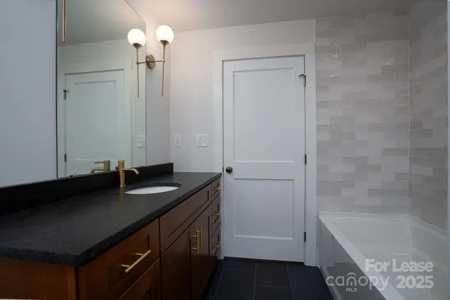 a bathroom with a granite countertop sink a toilet and bathtub