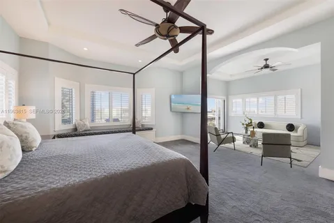 a spacious bedroom with a bed a table and chairs