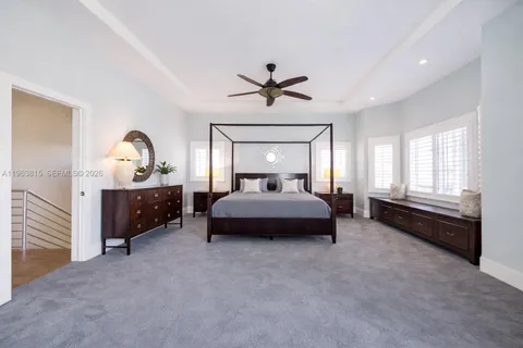 a spacious bedroom with a bed and a chandelier