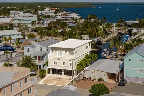 an aerial view of a house with swimming pool and outdoor seating