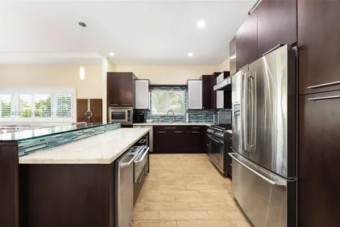 a modern kitchen with stainless steel appliances granite countertop a refrigerator and a sink