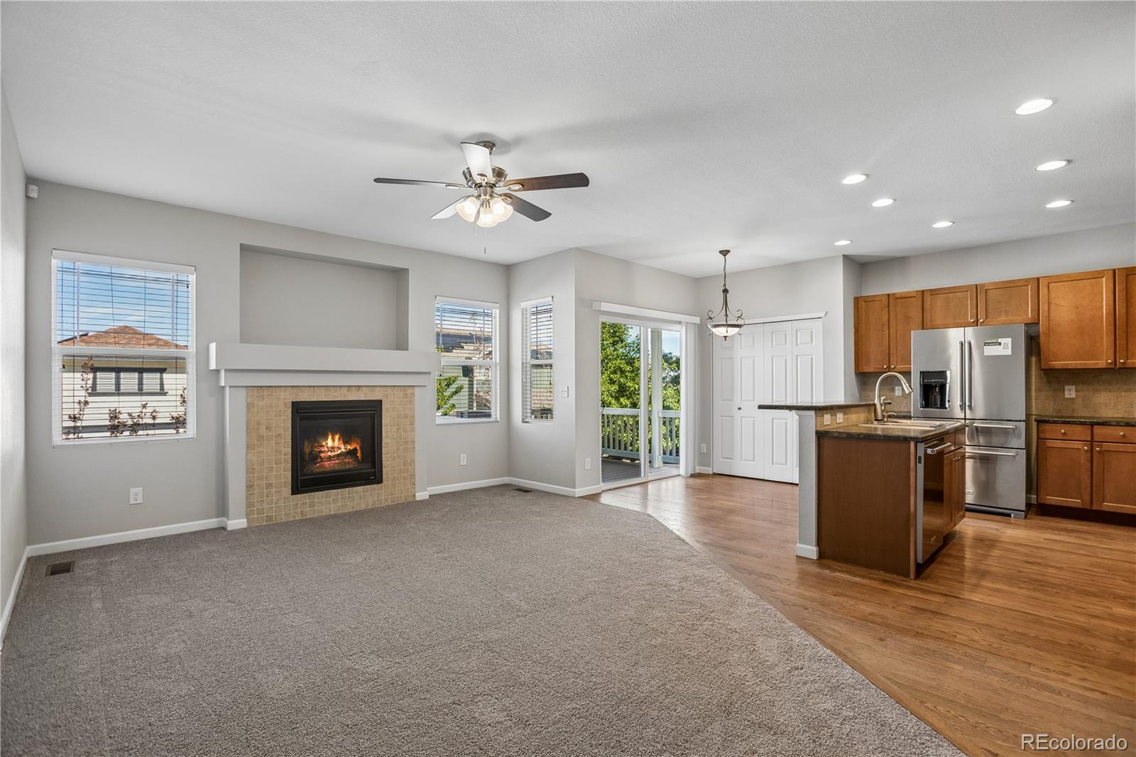 5031 South Rome Street Aurora, CO 80015 - Photo 4 of 39 a view of an empty room with a kitchen and a fireplace