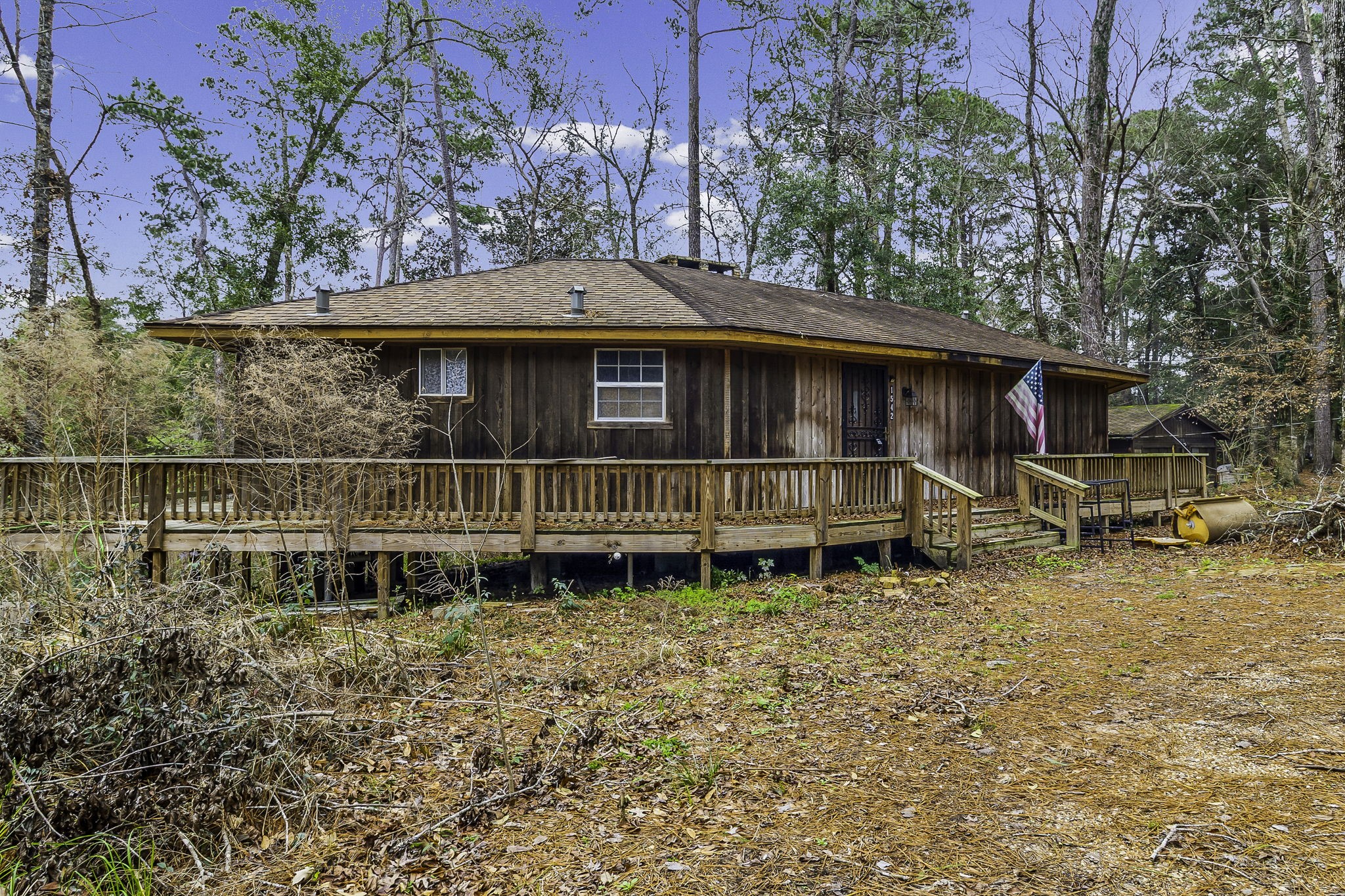1542 Hillbilly Heaven Road Livingston, TX 77351 - Photo 2 of 27 a blue swimming pool is sitting in front of a house