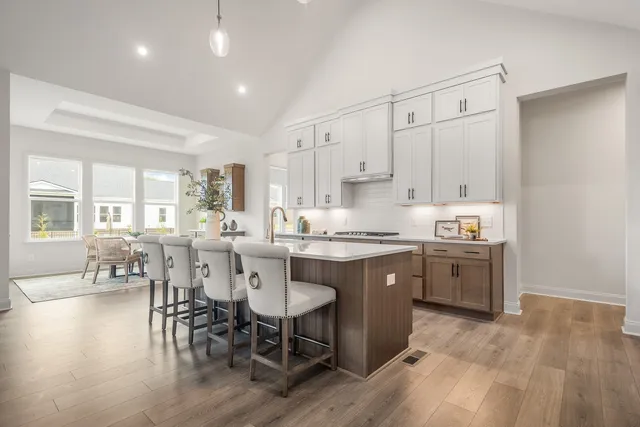 a kitchen with stainless steel appliances granite countertop a table chairs sink refrigerator and cabinets