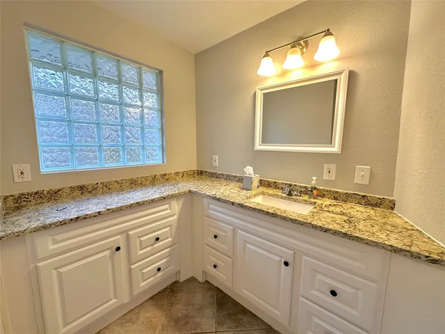 a view of bathroom with granite countertop cabinets