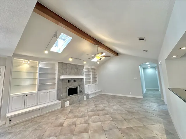 a view of an empty room with a fireplace and a window