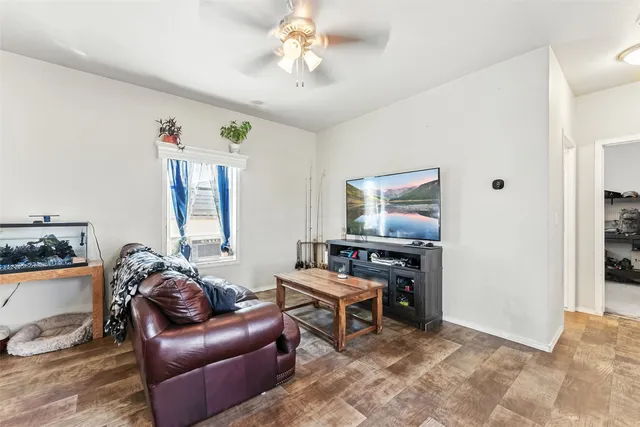 a living room with furniture a ceiling fan and a window
