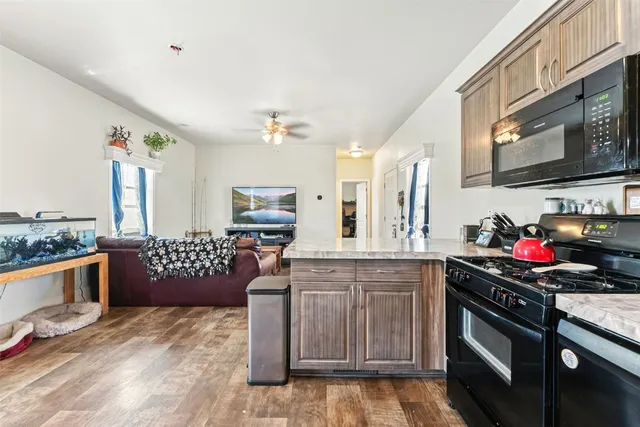 a kitchen with stainless steel appliances granite countertop a stove a sink and a microwave