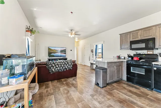 a large kitchen with kitchen island granite countertop a stove and cabinets
