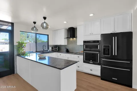 a kitchen with stainless steel appliances granite countertop a sink a stove and a microwave