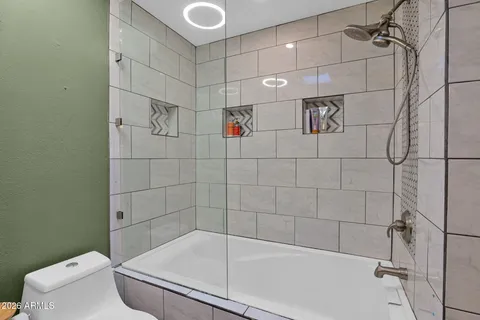 a bathroom with a granite countertop sink a toilet and mirror
