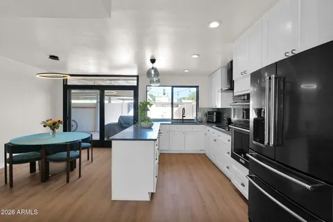 a kitchen with a refrigerator and a wooden floor