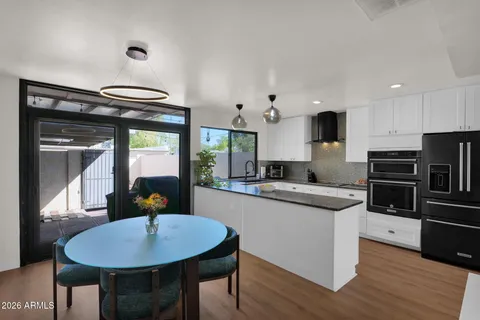a large kitchen with kitchen island a large counter space a sink appliances and cabinets