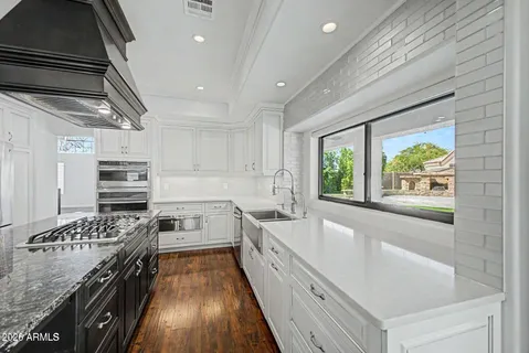 a kitchen with a stove a sink and wooden cabinets