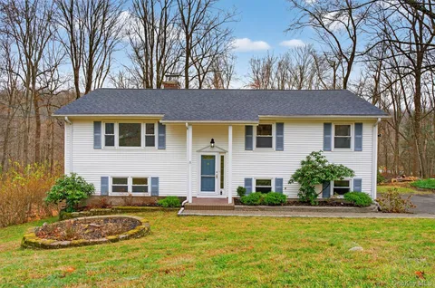 a front view of house with yard and green space