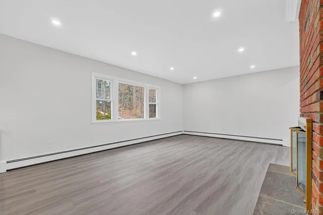 an empty room with wooden floor and window