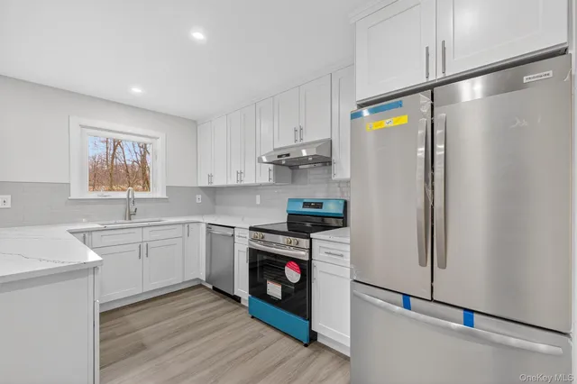 a kitchen with stainless steel appliances granite countertop a refrigerator and a stove top oven