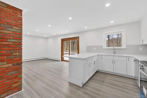 a large white kitchen with wooden floors and white walls