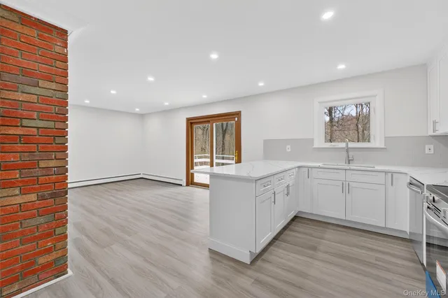 a large white kitchen with wooden floors and white walls