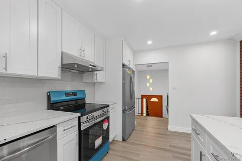 a kitchen with stainless steel appliances white cabinets and wooden floor