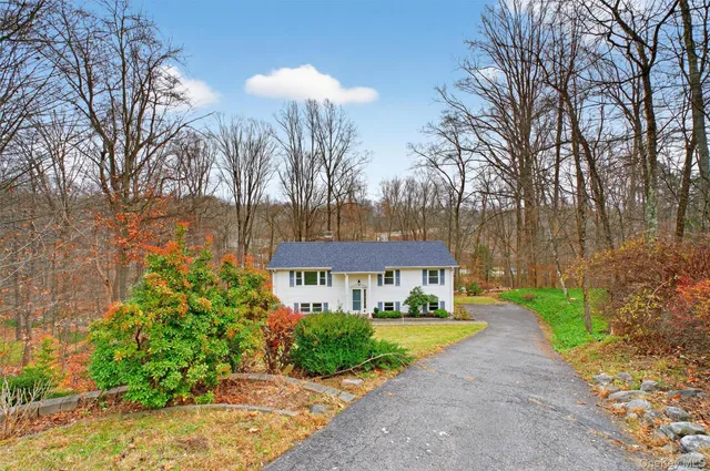 a front view of a house with a yard and trees