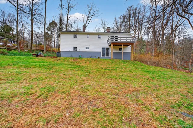 a view of a house with backyard and tree