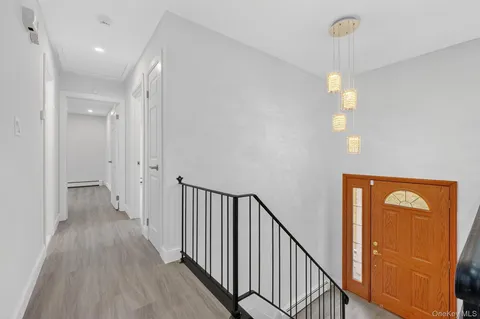 a view of a hallway with wooden floor and windows