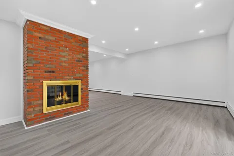 an empty room with wooden floor and fireplace
