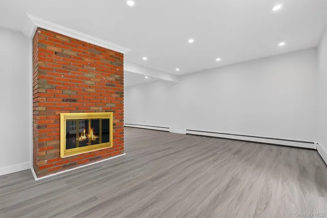 an empty room with wooden floor and fireplace