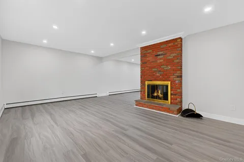 an empty room with wooden floor and fireplace