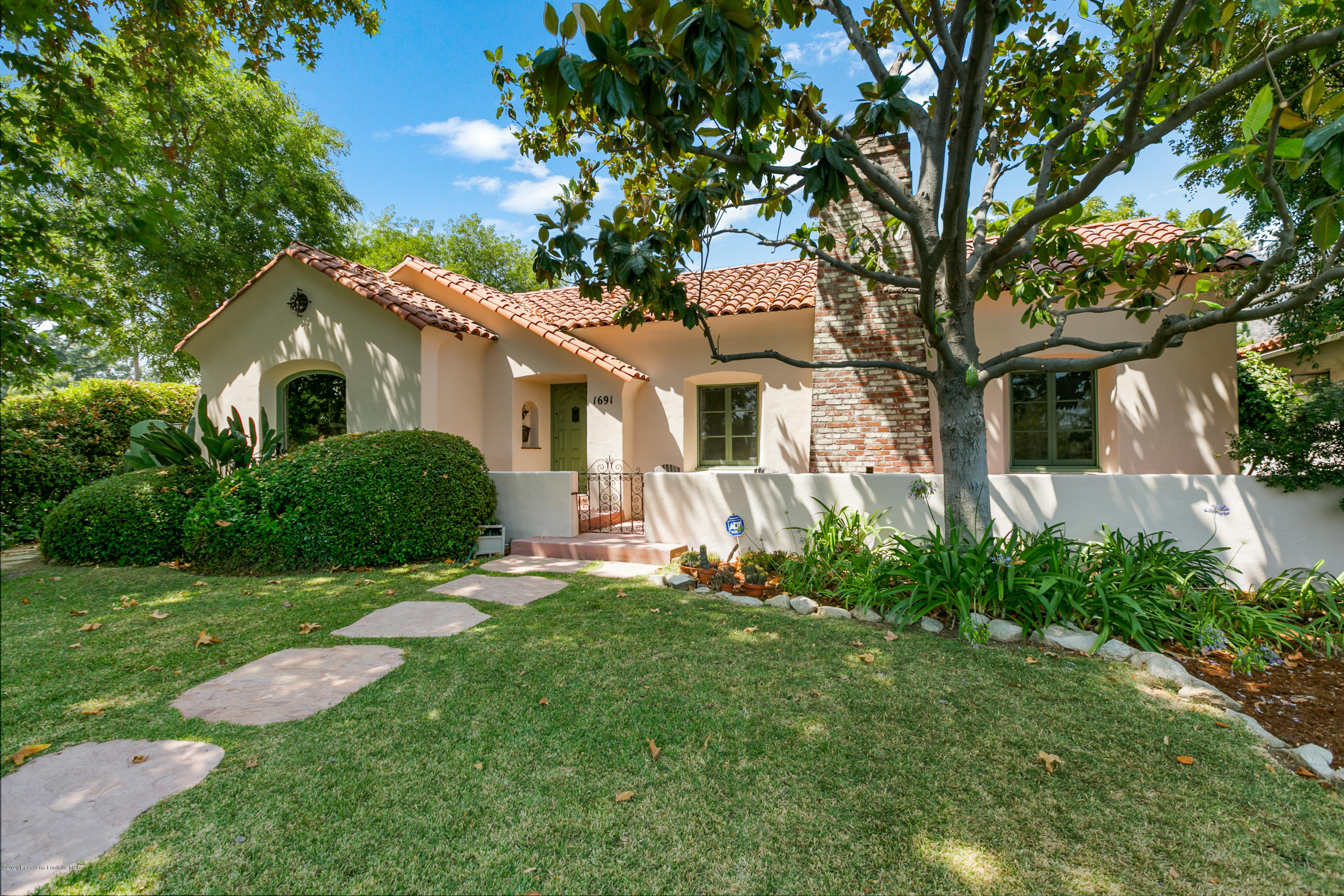 a front view of a house with a yard and trees