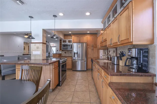 a kitchen with stainless steel appliances granite countertop a sink a stove and a refrigerator