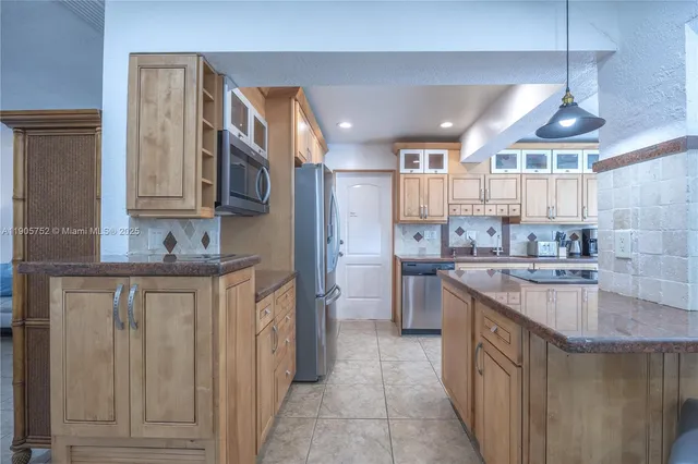 a kitchen with stainless steel appliances granite countertop a sink a stove and a refrigerator