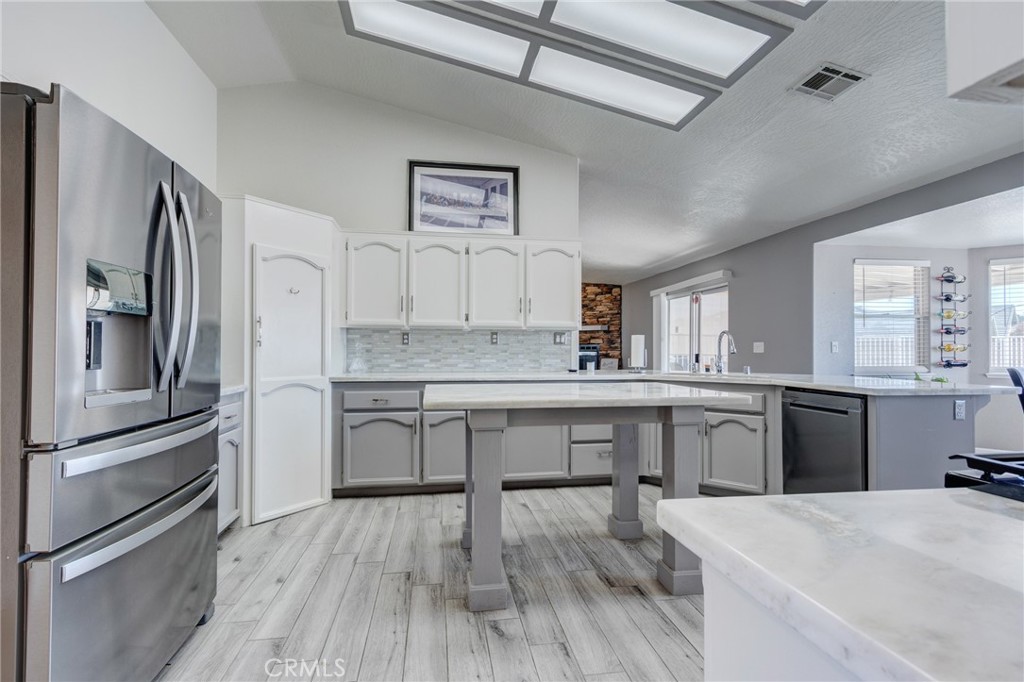 19783 Lara Lane Apple Valley, CA 92308 - Photo 13 of 42 a kitchen with stainless steel appliances granite countertop a refrigerator a stove and white cabinets