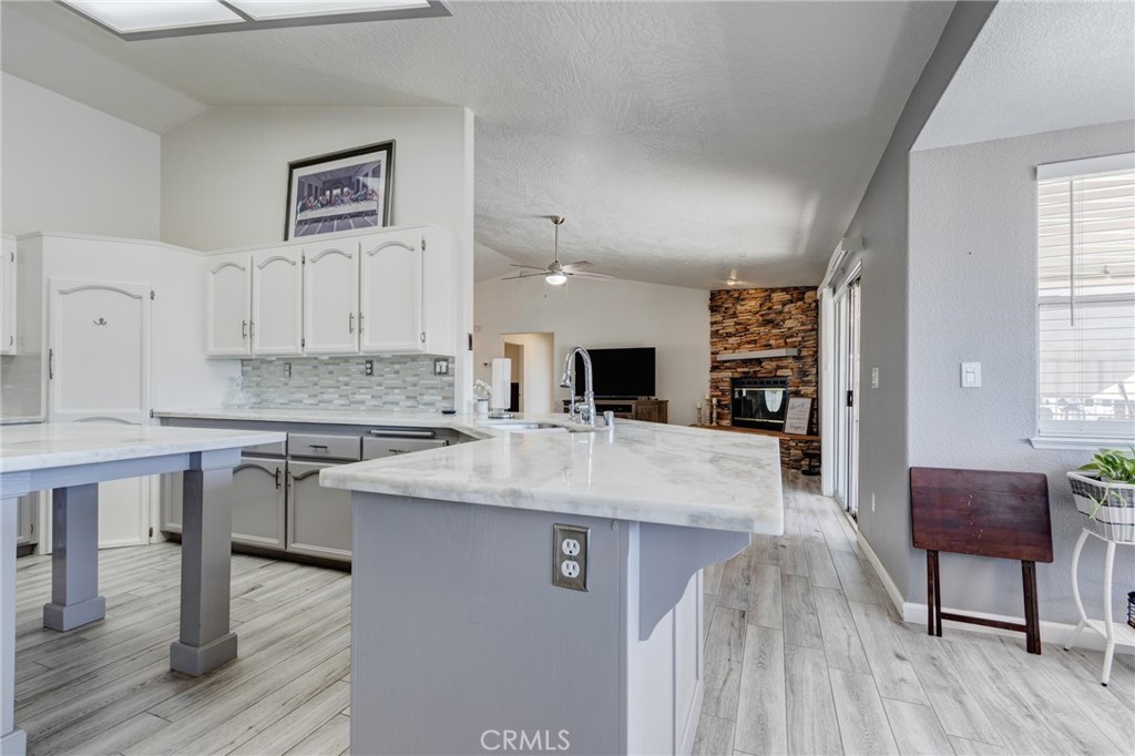 19783 Lara Lane Apple Valley, CA 92308 - Photo 14 of 42 a large kitchen with stainless steel appliances kitchen island granite countertop a sink and cabinets