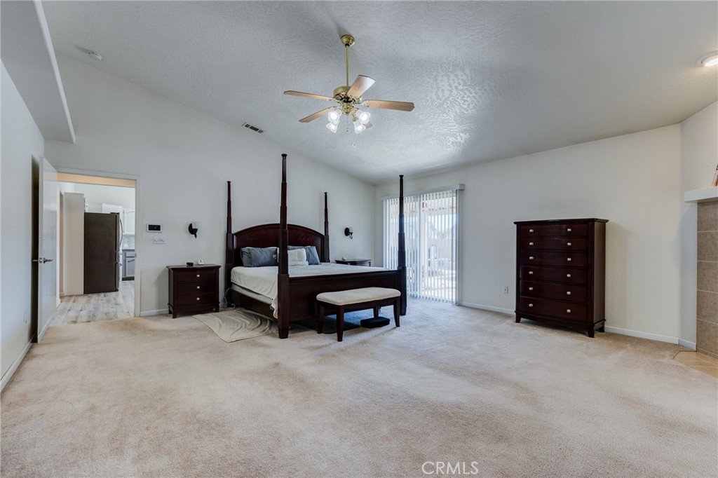 19783 Lara Lane Apple Valley, CA 92308 - Photo 27 of 42 a spacious bedroom with a bed and a lamp on a dresser