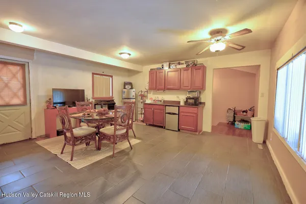 a living room with furniture a flat screen tv and kitchen view