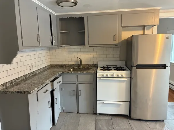 a kitchen with a refrigerator sink and cabinets