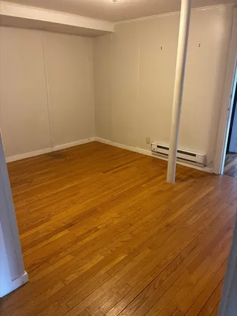 a view of an empty room with wooden floor